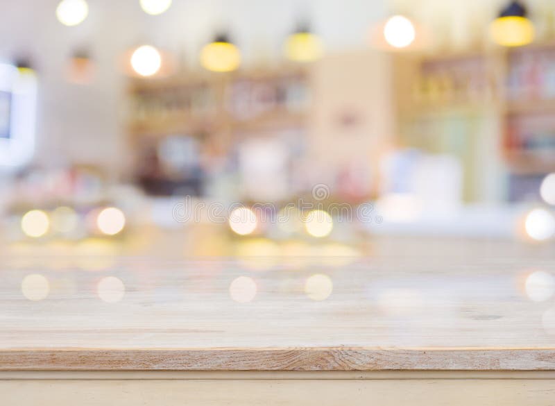 Unscharfes Bild des Caféinnenraums mit Holztisch in der Front lizenzfreies stockfoto