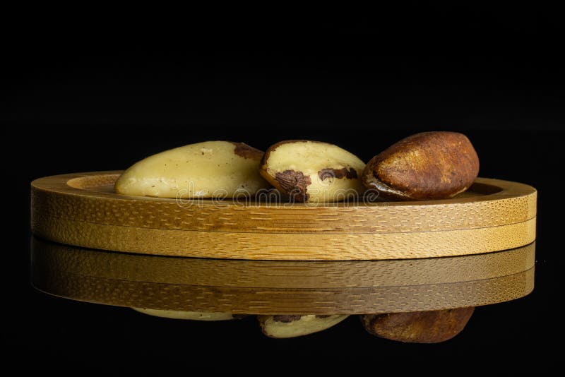 Unshelled brazil nut isolated on black glass