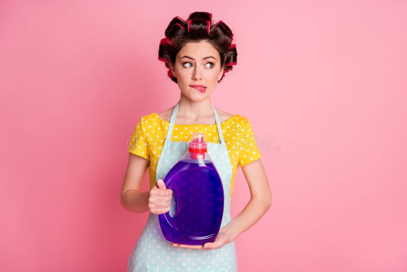 Unsure girl hold wash powder bottle bite lips look copyspace hesitate wear yellow dotted t-shirt  pastel color