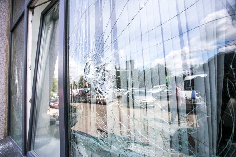 Broken glass window of the modern building reflecting blue sky. Broken glass window of the modern building reflecting blue sky