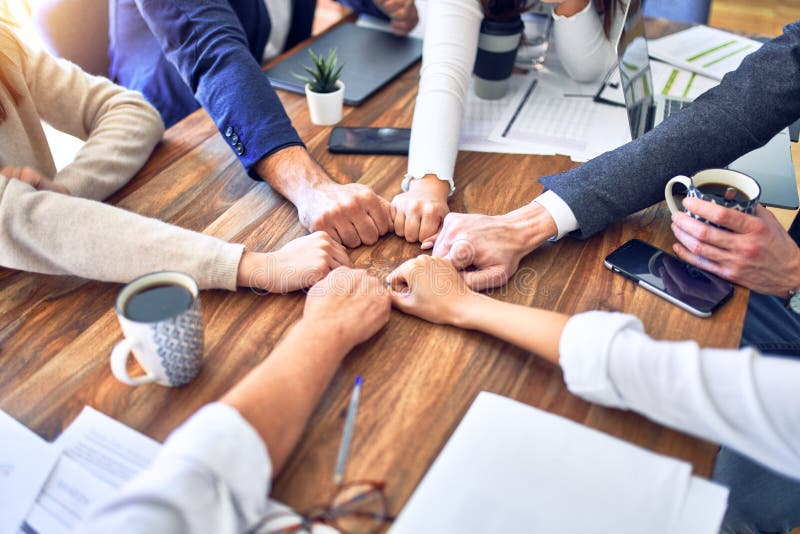 Unternehmensgruppe, die im Büro auf die Faust stößt lizenzfreie stockbilder