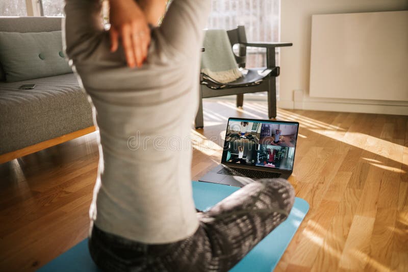 Fitness coach teaching yoga online to group of people. Yoga trainer demonstrating yoga poses to students via video conference. Fitness coach teaching yoga online to group of people. Yoga trainer demonstrating yoga poses to students via video conference