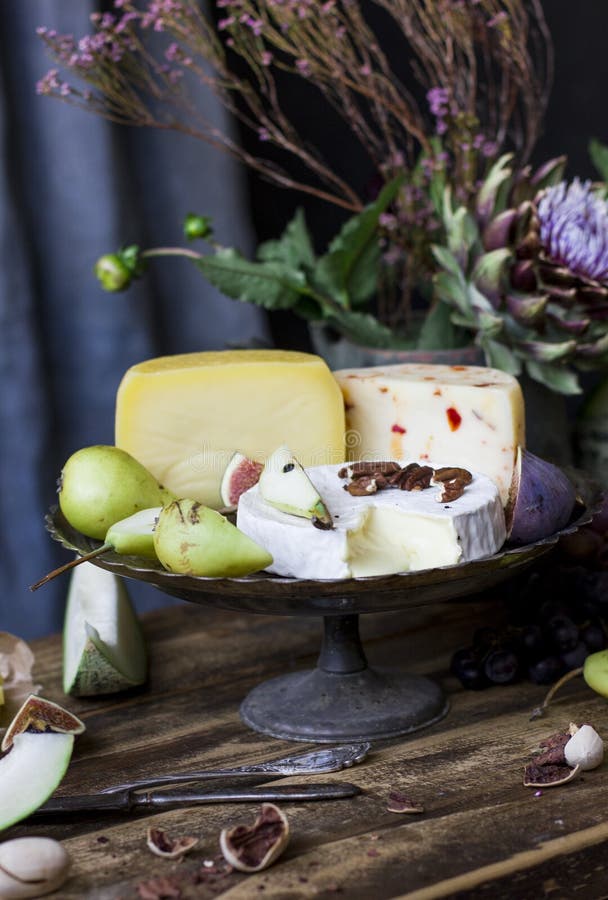 Unterschiedlicher Käse, frische Frucht und Gartenblumen auf dem alten Holz stockbilder Unterschiedlicher Käse, frische Frucht und Gartenblumen auf dem alten Holz stockbilder