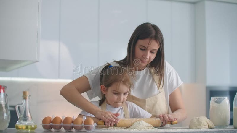 Unterstützung der Tochter der Mutter, des Teigs bereitzustellen. Mutter und Tochter den Teig für die Herstellung von Cookies berei stock video footage