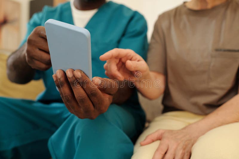 Untersuchung von Tablet-Geräten durch Pflegepersonal stockbilder
