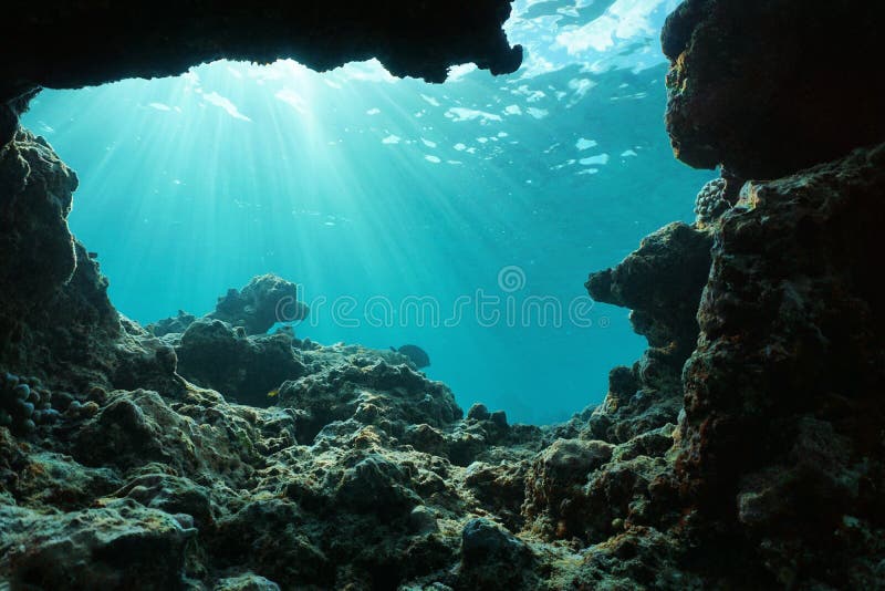 Underwater sunlight through water surface from a hole in a rocky ocean floor, natural scene, Pacific ocean, outer reef of Huahine, French Polynesia. Underwater sunlight through water surface from a hole in a rocky ocean floor, natural scene, Pacific ocean, outer reef of Huahine, French Polynesia