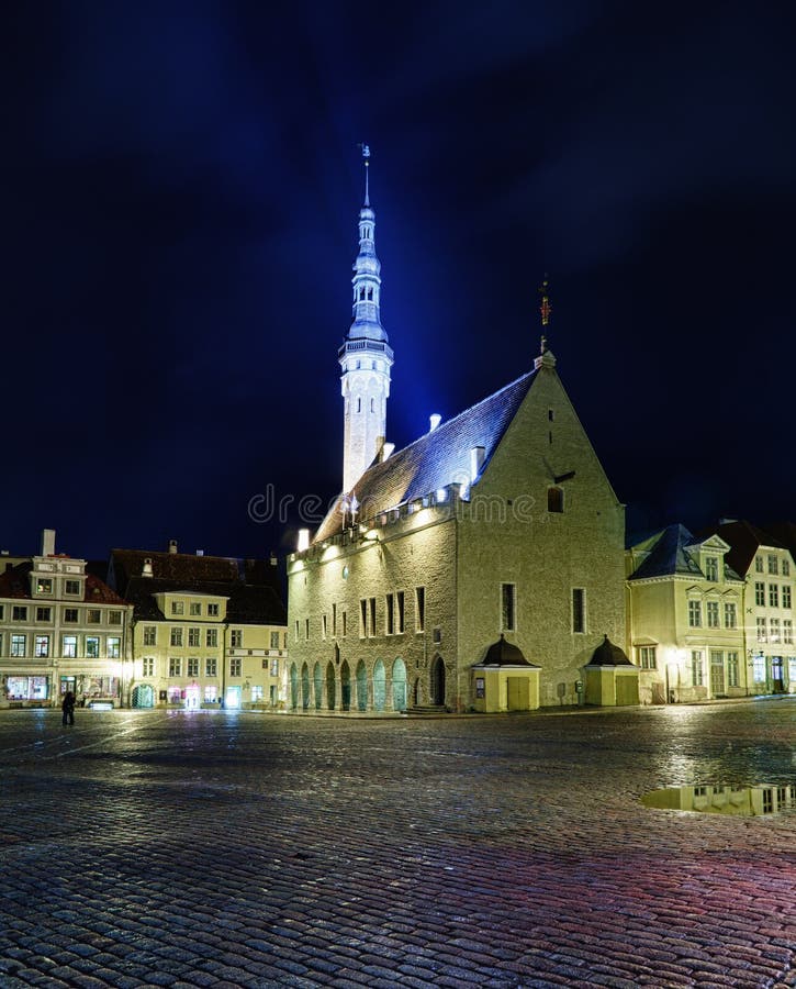 Tallinn town hall at night in Raekoya square showing the floodlit spire and tower of the hall. Tallinn town hall at night in Raekoya square showing the floodlit spire and tower of the hall