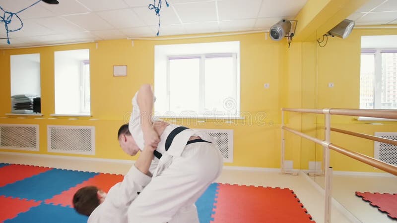 Uomini atletici impegnati in arte marziale degli aikidi Un uomo afferra il suo oppositore e lo getta più