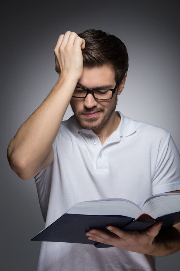 Uomini che leggono un libro. Ritratto dei giovani che leggono un libro e una HOL immagine stock libera da diritti Uomini che leggono un libro. Ritratto dei giovani che leggono un libro e una HOL immagine stock libera da diritti