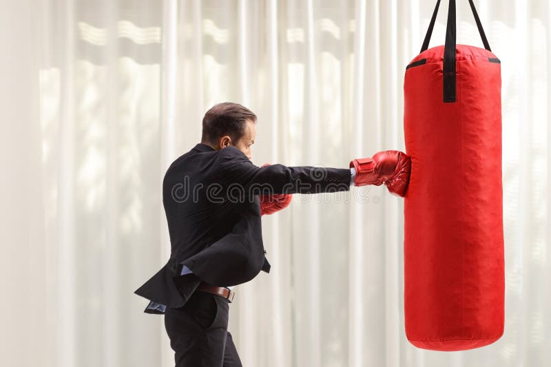 Uomini d'affari che colpiscono un sacco da boxe immagini stock