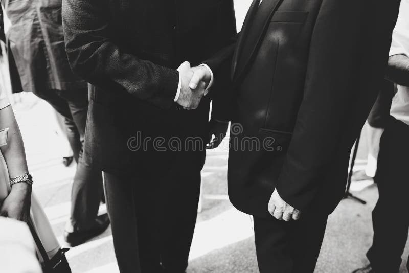 Uomini nella scossa nera dei vestiti mani fotografia stock Uomini nella scossa nera dei vestiti mani fotografia stock