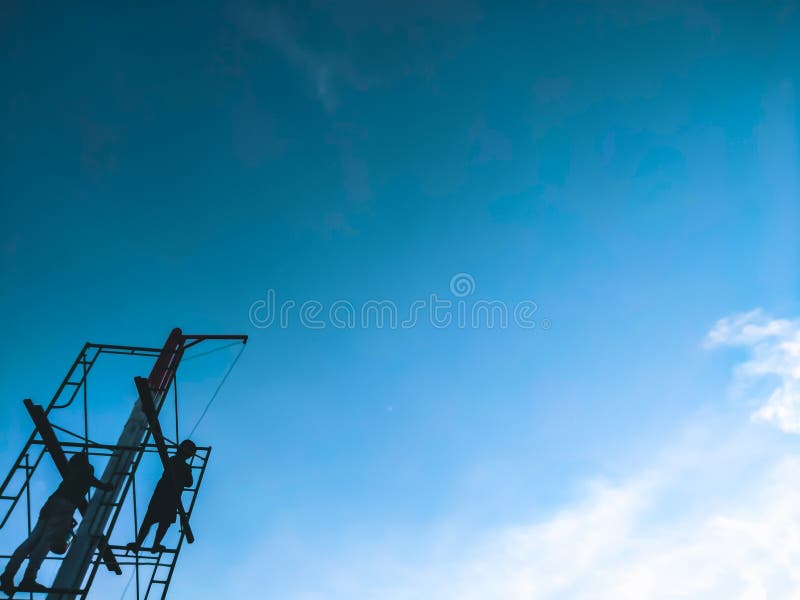Uomini in piedi sulla torre di ponteggio di fortuna il lavoratore ricostruisca una sezione esterna di una casa in fase di ristrut fotografia stock libera da diritti Uomini in piedi sulla torre di ponteggio di fortuna il lavoratore ricostruisca una sezione esterna di una casa in fase di ristrut fotografia stock libera da diritti
