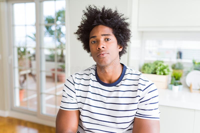 Uomo africano americano con una camicia a strisce con espressione seria sulla faccia immagini stock