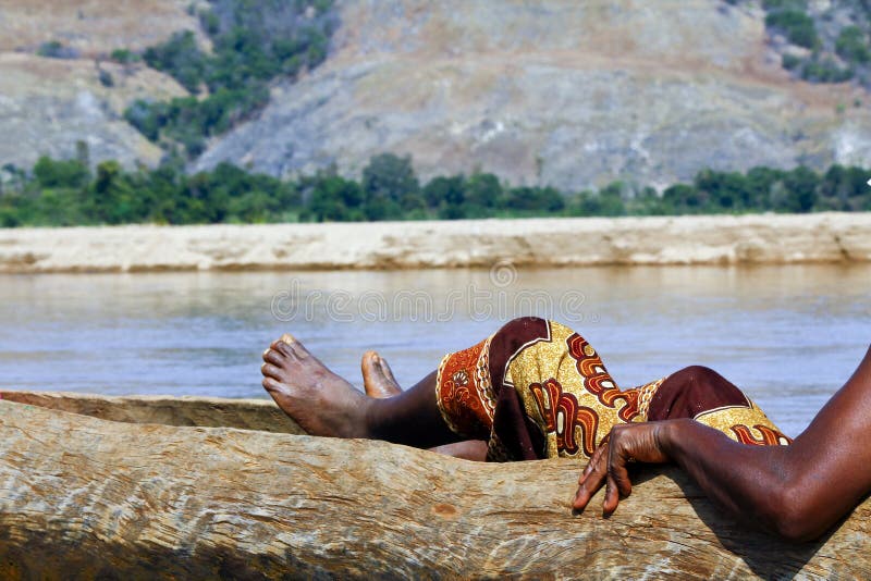 Uomo africano che riposa in canoa tradizionale immagine stock libera da diritti Uomo africano che riposa in canoa tradizionale immagine stock libera da diritti