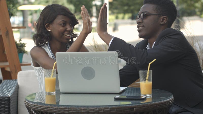 Uomo africano in vestito convenzionale che spiega strategia aziendale al suo collega femminile africano che per mezzo del compute fotografie stock libere da diritti Uomo africano in vestito convenzionale che spiega strategia aziendale al suo collega femminile africano che per mezzo del compute fotografie stock libere da diritti