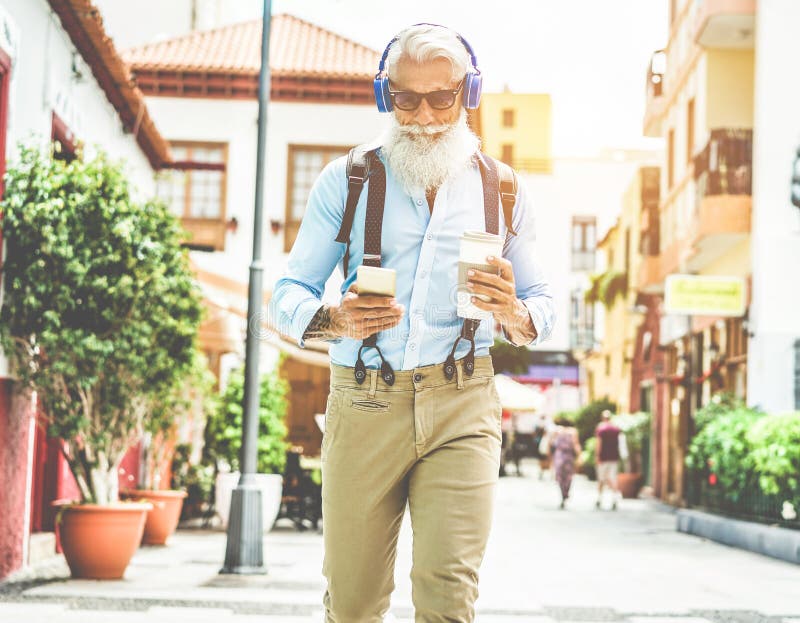 Uomo anziano alla moda che usa l'app per smartphone e beve caffè nel centro della città all'aperto - Maschile maturo che si diver fotografia stock Uomo anziano alla moda che usa l'app per smartphone e beve caffè nel centro della città all'aperto - Maschile maturo che si diver fotografia stock