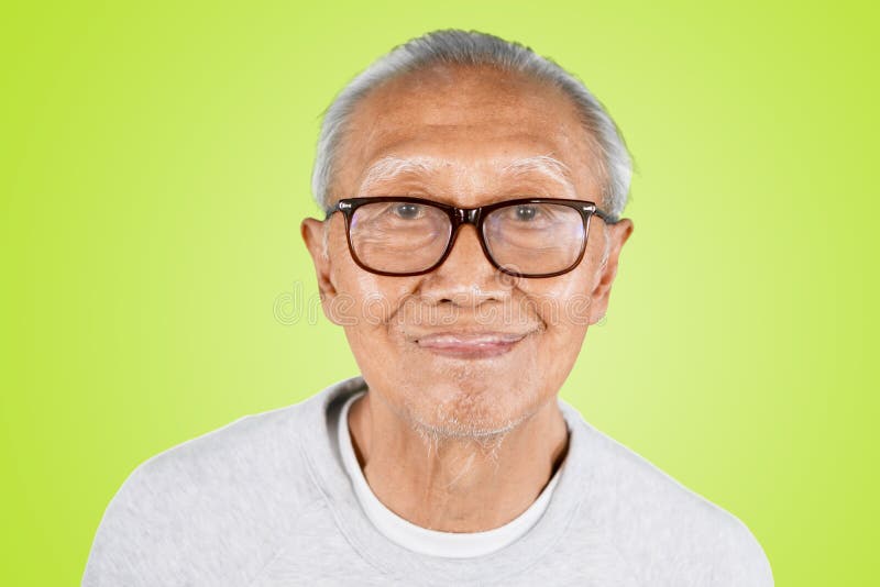 Uomo anziano che mostra la sua lingua nello studio fotografia stock Uomo anziano che mostra la sua lingua nello studio fotografia stock