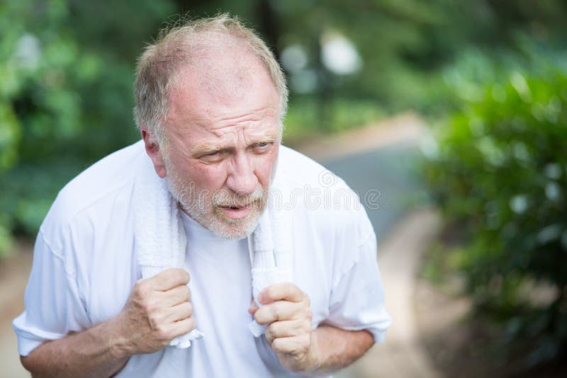 Closeup portrait, senior guy holding towel, very tired, exhausted from over exertion, sun stroke, isolated outdoors outside green trees background. Closeup portrait, senior guy holding towel, very tired, exhausted from over exertion, sun stroke, isolated outdoors outside green trees background