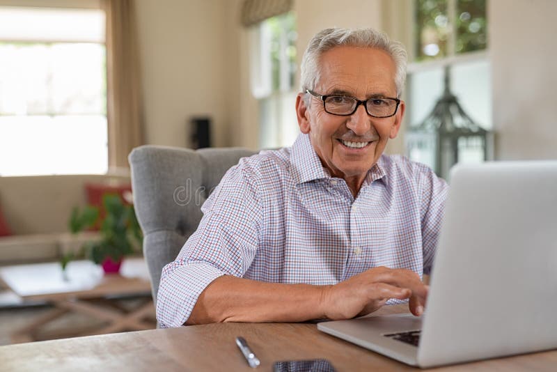 Uomo anziano sorridente felice con il computer portatile