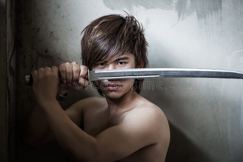 Uomo asiatico cattivo con la spada di giustizia fotografia stock Uomo asiatico cattivo con la spada di giustizia fotografia stock