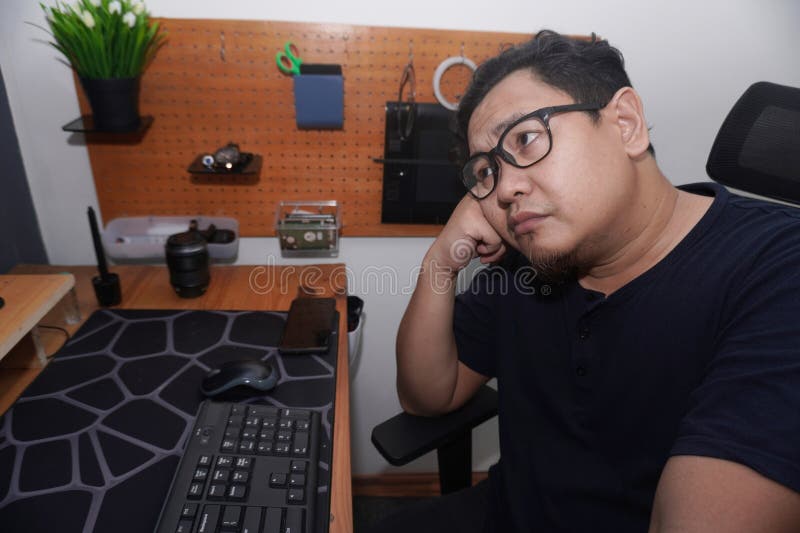Uomo asiatico che batte computer su computer da casa freelancer che lavora in modalità remota online concetto di lavoro espression fotografia stock libera da diritti