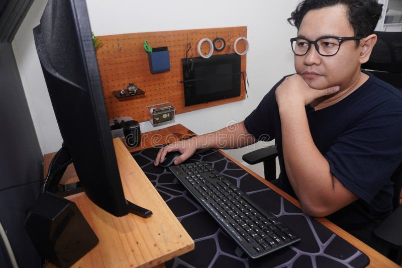 Uomo asiatico che batte il computer del pc da freelancer che lavora in remoto online e concetto di lavoro felice espressione sorri fotografie stock
