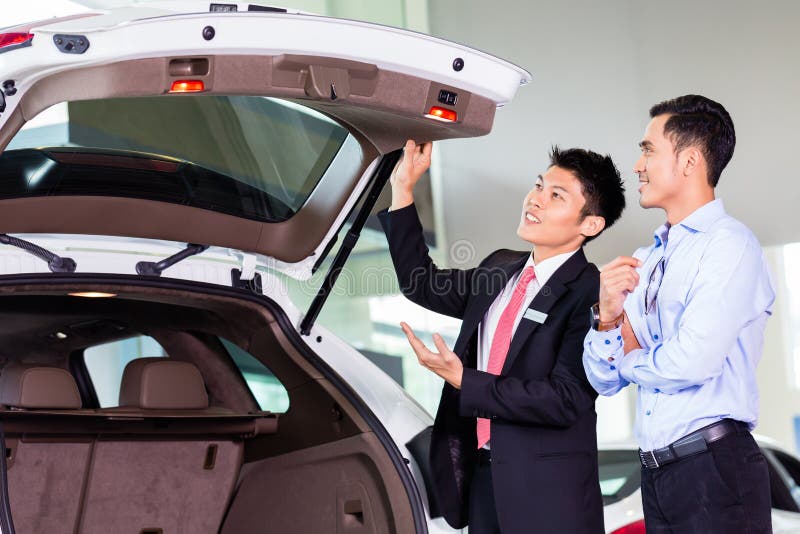 Uomo asiatico che esamina automobile nella gestione commerciale immagini stock libere da diritti Uomo asiatico che esamina automobile nella gestione commerciale immagini stock libere da diritti