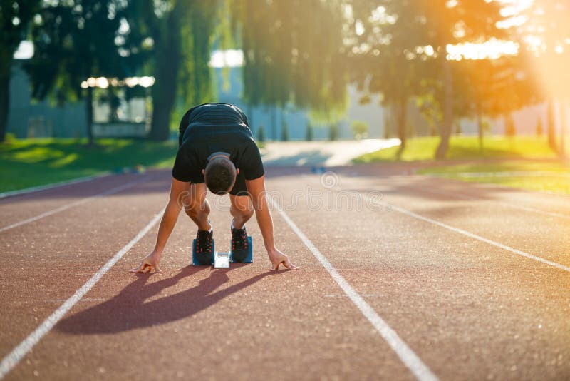 Uomo atletico sulla pista che inizia a funzionare Concetto sano di forma fisica con lo stile di vita attivo immagine stock libera da diritti Uomo atletico sulla pista che inizia a funzionare Concetto sano di forma fisica con lo stile di vita attivo immagine stock libera da diritti