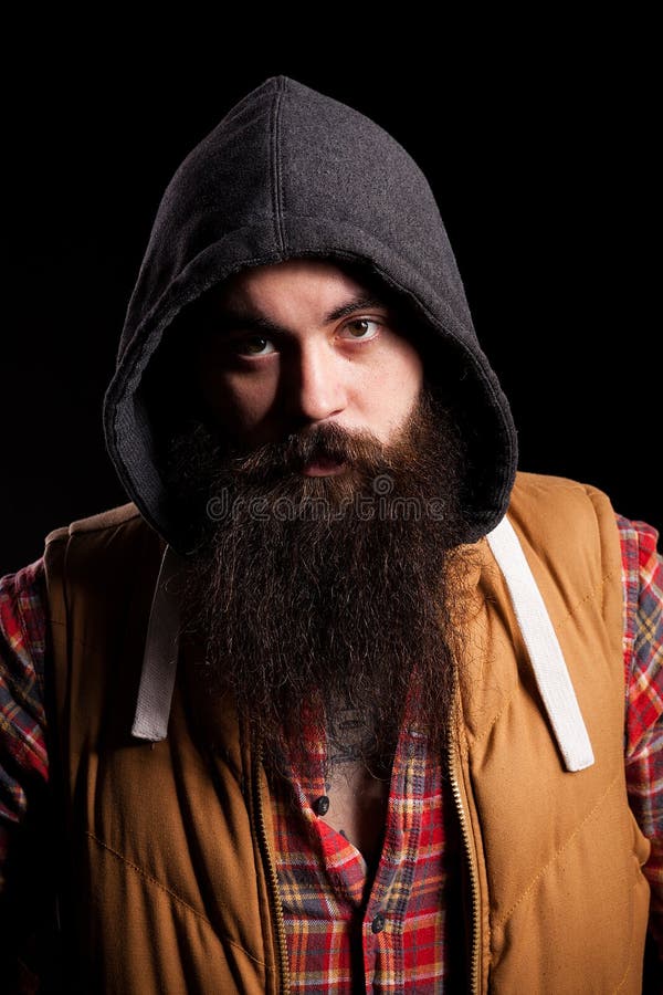 Uomo barbuto dei pantaloni a vita bassa che indossa un cappuccio immagine stock Uomo barbuto dei pantaloni a vita bassa che indossa un cappuccio immagine stock