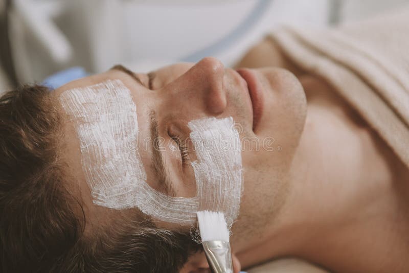 Uomo bello che ottiene trattamento facciale dello skincare fotografia stock libera da diritti Uomo bello che ottiene trattamento facciale dello skincare fotografia stock libera da diritti