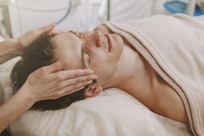 Uomo bello che ottiene trattamento facciale dello skincare immagini stock Uomo bello che ottiene trattamento facciale dello skincare immagini stock