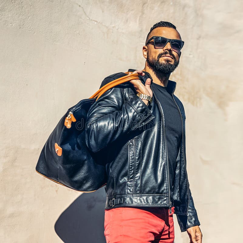 Uomo brutale bello della barba con la borsa - modo all'aperto fotografie stock