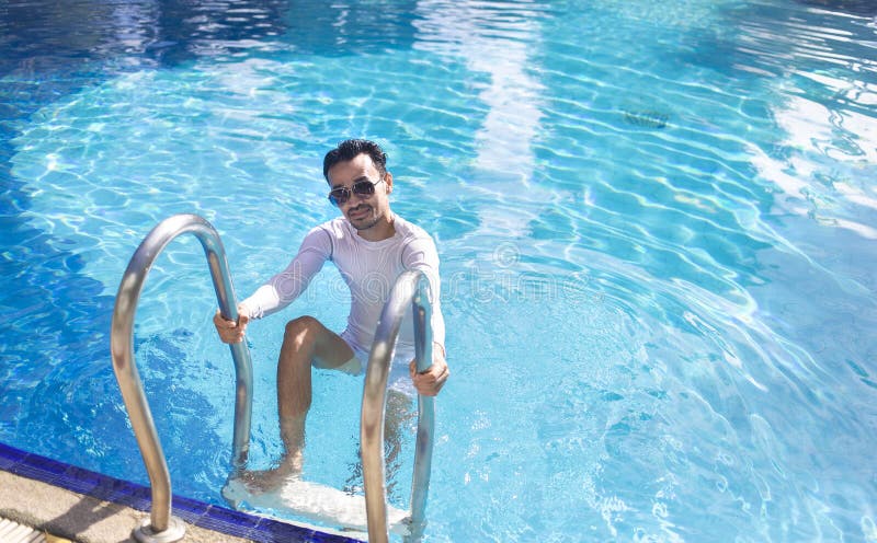 Uomo in camicia bianca nuotata in piscina immagini stock libere da diritti