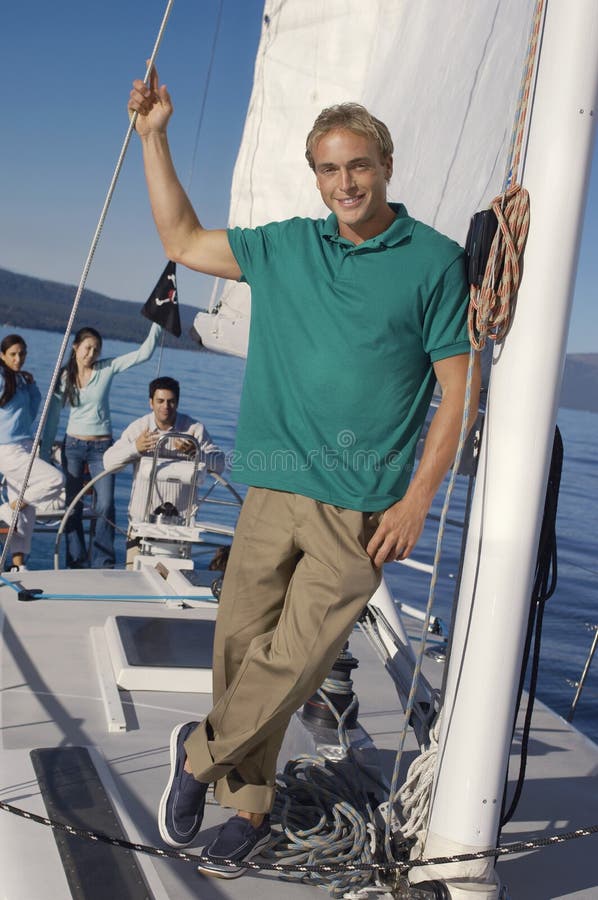 Uomo caucasico che sta in barca a vela fotografie stock libere da diritti Uomo caucasico che sta in barca a vela fotografie stock libere da diritti