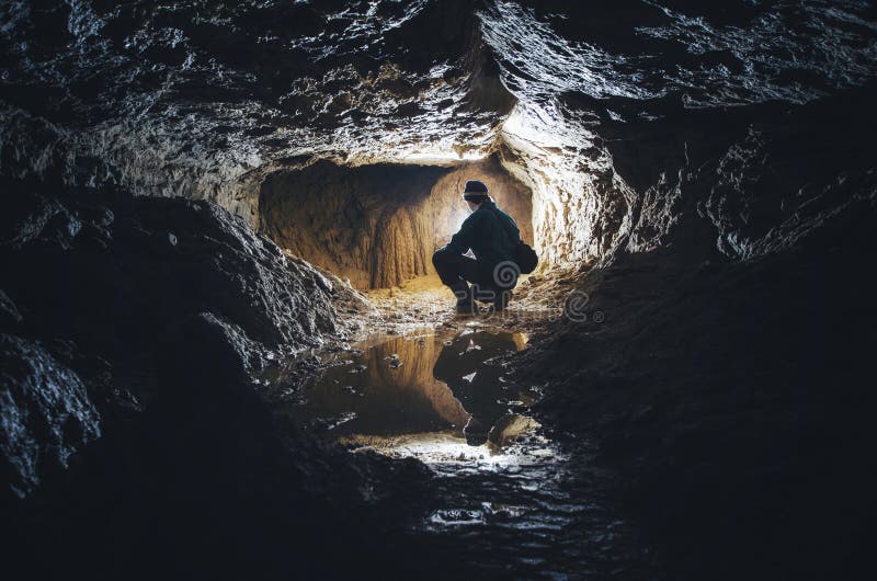 Man in underground dark cave with reflection. Man in underground dark cave with reflection