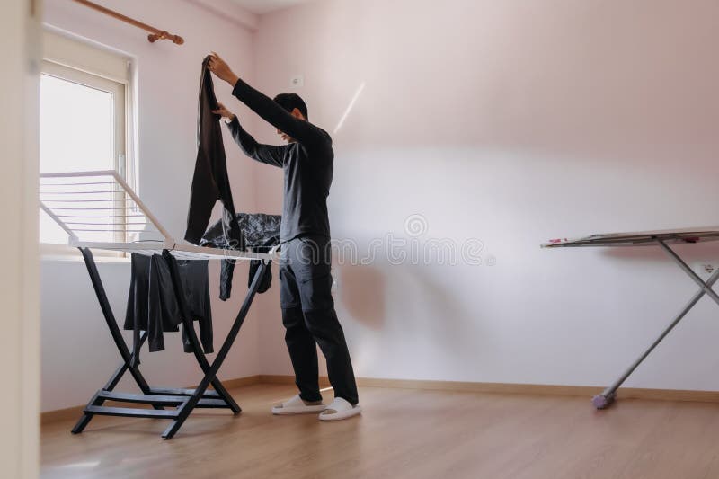 Uomo Che Appende Vestiti Per Asciugare Dal Sole Dalle Finestre. Routine  Domestica. Fotografia Stock - Immagine di sicuro, essiccatore: 269545632