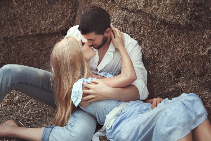 Uomo che bacia una donna nel hayloft immagini stock Uomo che bacia una donna nel hayloft immagini stock