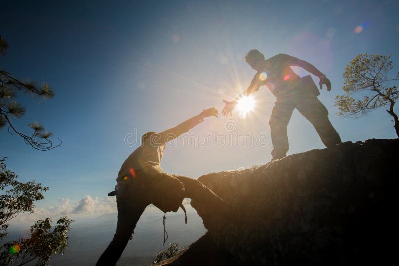 Uomo che contribuisce a scalare la roccia fotografia stock libera da diritti Uomo che contribuisce a scalare la roccia fotografia stock libera da diritti