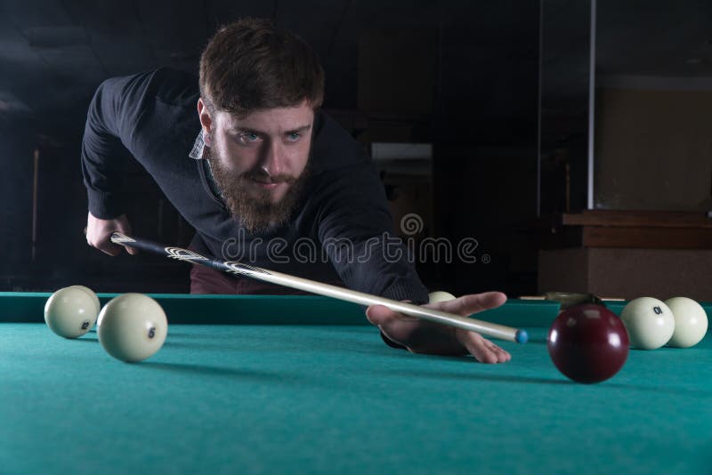 Uomo che gioca il biliardo Concentrazione intaschi la palla immagine stock Uomo che gioca il biliardo Concentrazione intaschi la palla immagine stock