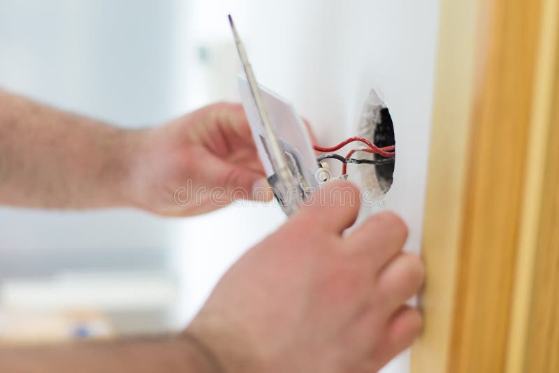 Uomo che installa interruttore della luce fotografia stock libera da diritti Uomo che installa interruttore della luce fotografia stock libera da diritti