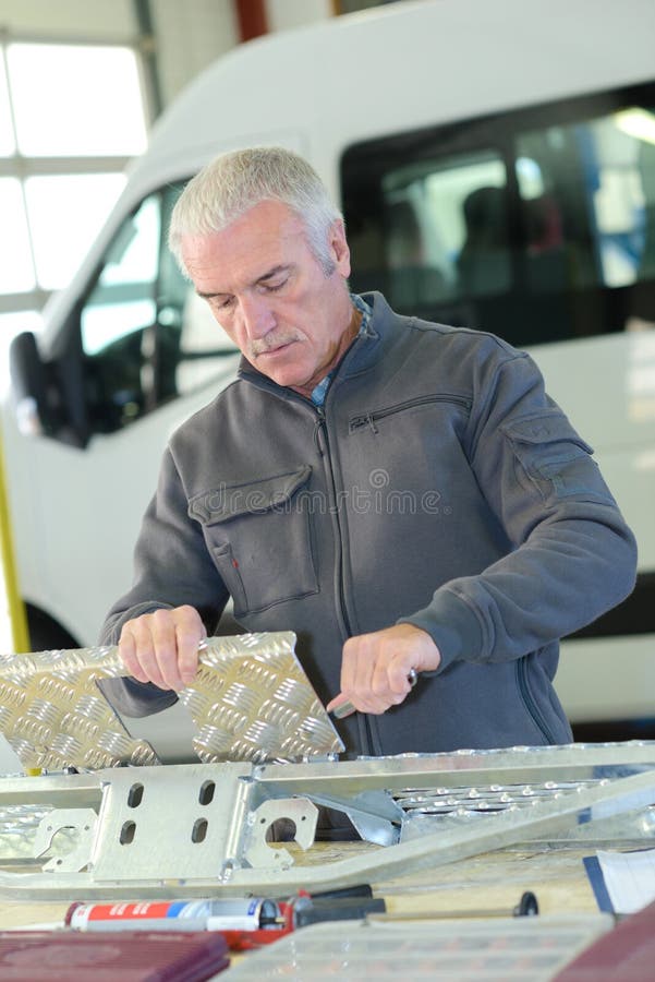 Uomo che lavora con il checkerplate immagine stock libera da diritti Uomo che lavora con il checkerplate immagine stock libera da diritti
