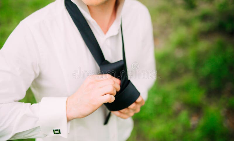 Uomo che lega suo legame Lo sposo che lega il suo legame Accesso dello sposo di nozze fotografie stock Uomo che lega suo legame Lo sposo che lega il suo legame Accesso dello sposo di nozze fotografie stock