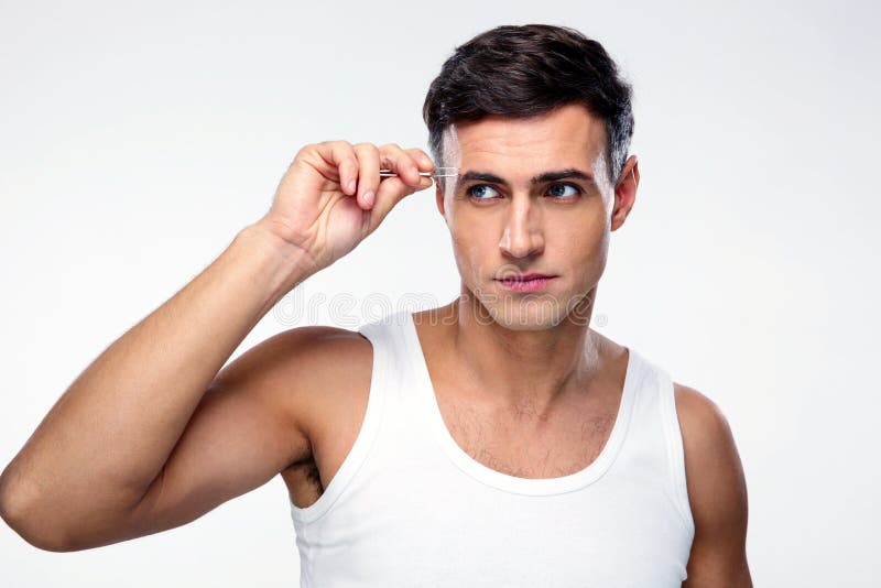 Uomo che rimuove i capelli del sopracciglio con depilare immagine stock Uomo che rimuove i capelli del sopracciglio con depilare immagine stock