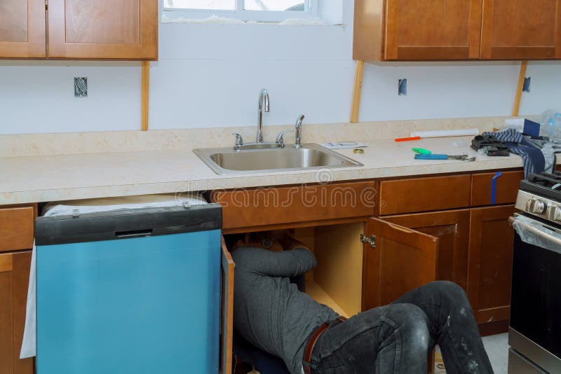 Man plumber repairing sink pipe in the kitchen pipes of a washbasin. Man plumber repairing sink pipe in the kitchen pipes of a washbasin