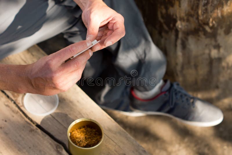 Uomo che rotola un giunto della cannabis immagini stock Uomo che rotola un giunto della cannabis immagini stock
