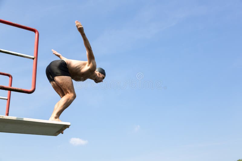 Uomo che salta giù trampolino alla piscina