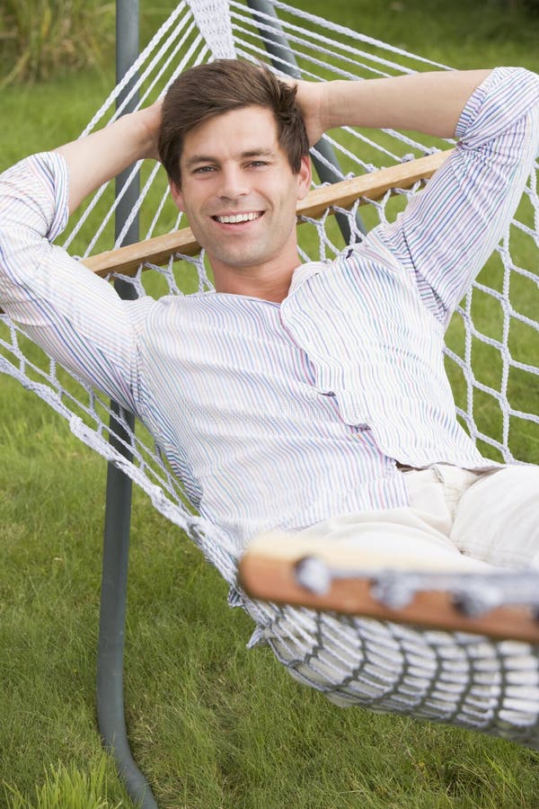 Uomo che si distende nel sorridere del hammock fotografie stock libere da diritti Uomo che si distende nel sorridere del hammock fotografie stock libere da diritti