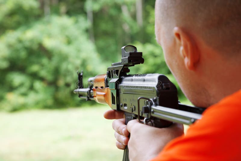 Uomo che spara un'arma automatica fotografia stock Uomo che spara un'arma automatica fotografia stock