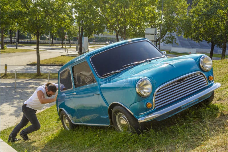 Uomo che spinge la sua automobile fotografia stock libera da diritti Uomo che spinge la sua automobile fotografia stock libera da diritti
