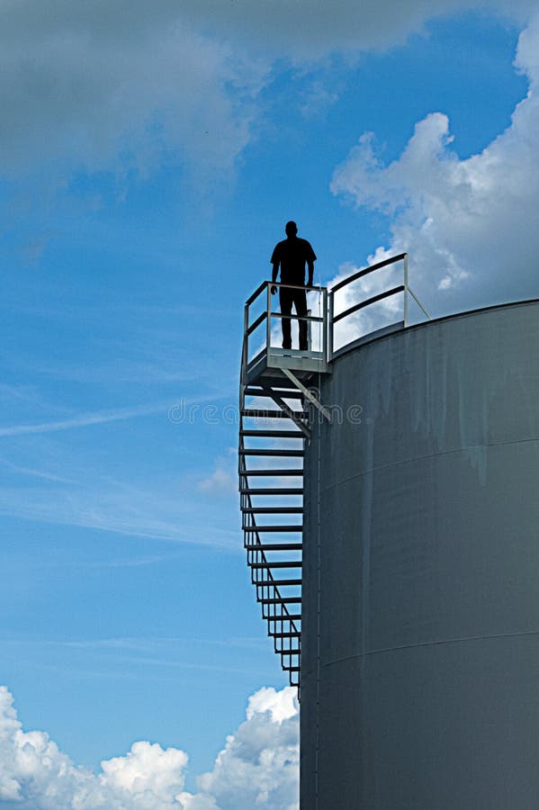 Uomo che sta sopra la torre di acqua immagine stock libera da diritti Uomo che sta sopra la torre di acqua immagine stock libera da diritti